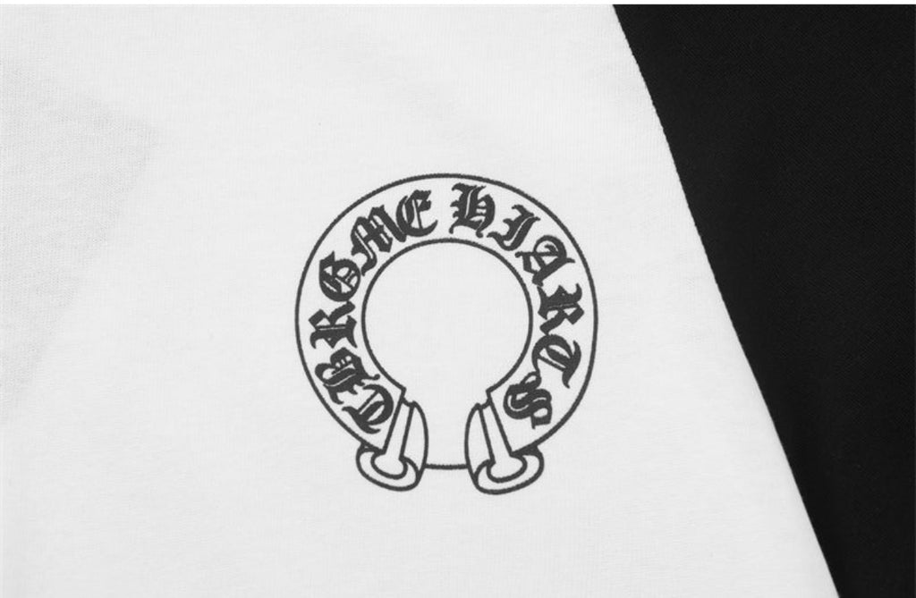 A close-up of a white garment featuring a black circular graphic with gothic lettering and a stylized ring design.
